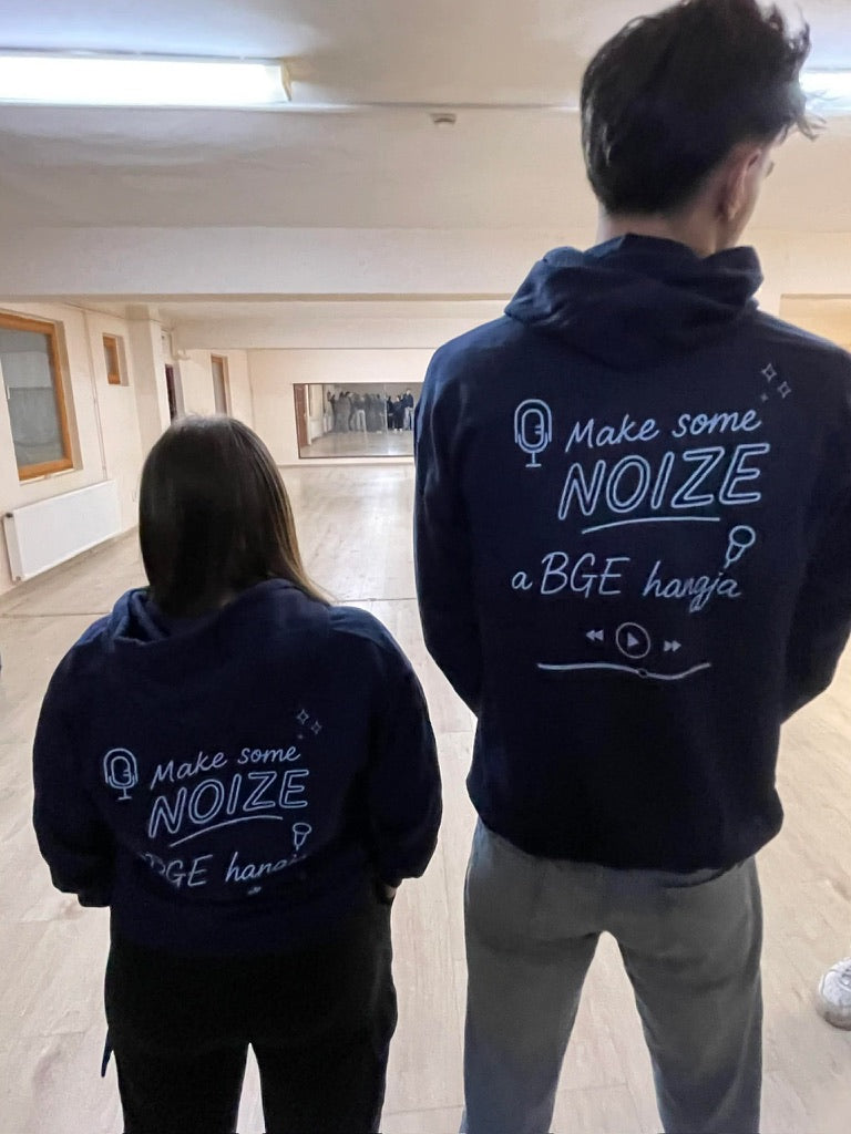 Két diák hátulról, Make some NOIZE feliratos sötétkék kapucnisban